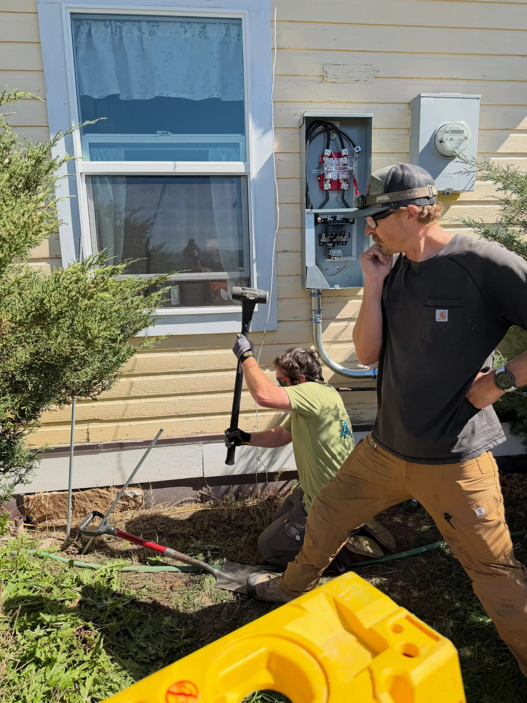 Two Animas City Electric electricians working beside a new panel on a house in Mancos