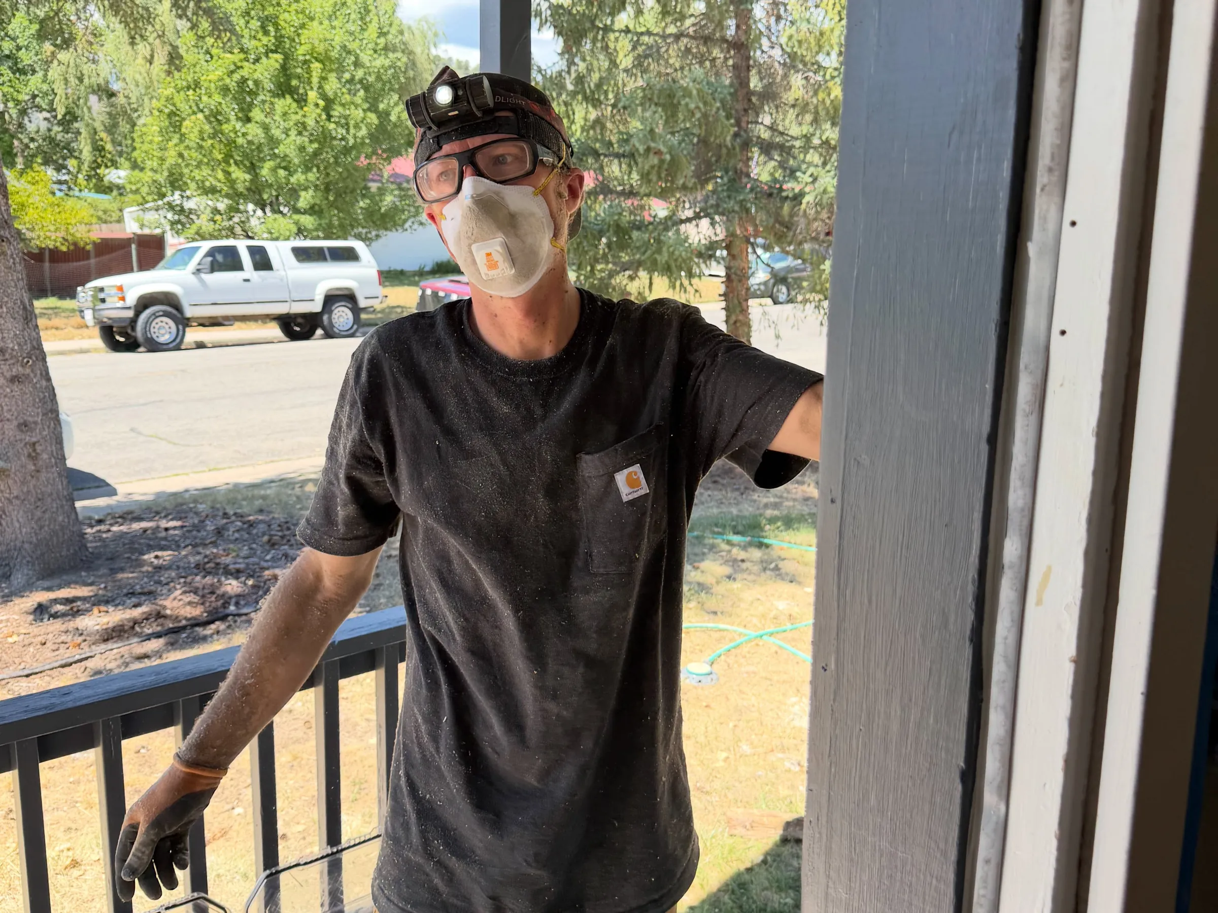 An Animas City Electric electrician in work gloves on a home's front porch