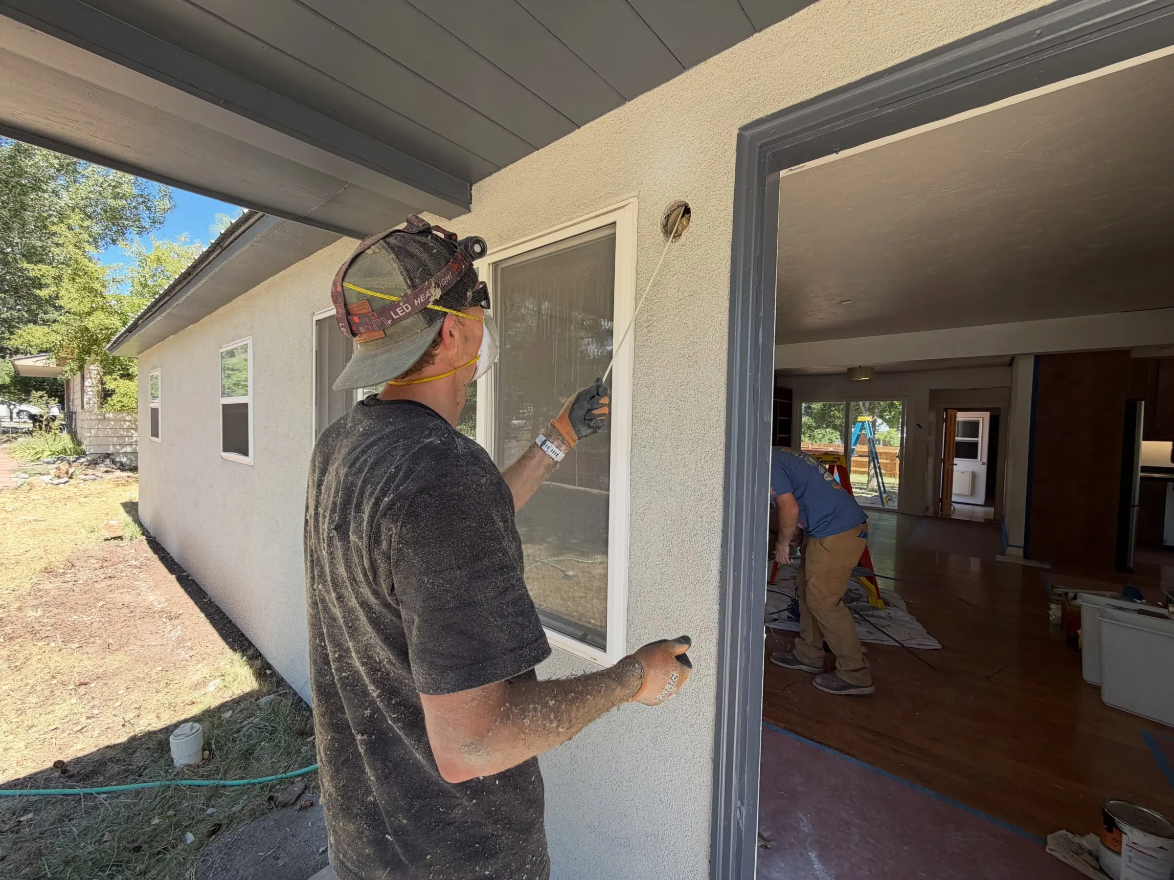 An electrician running wiring at the doorway of a home remodel