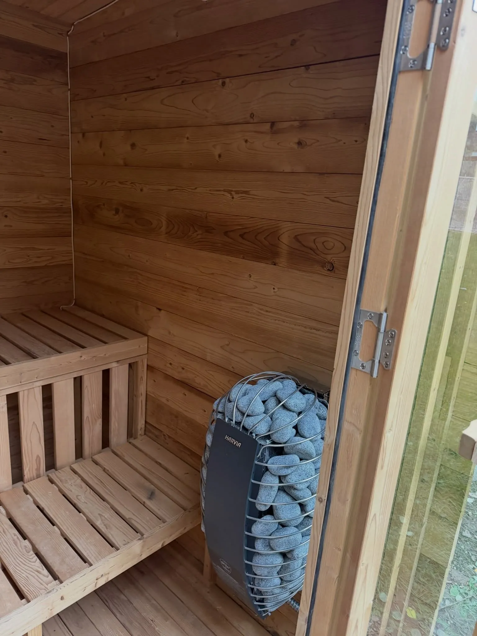 A cedar sauna interior with its electric heater installed